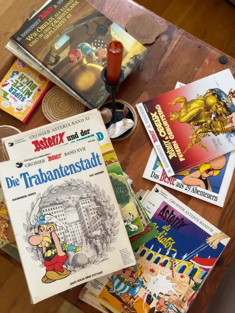 Alte Asterix-Comics liegen aufgeschlagen auf einem Holztisch